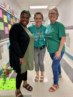 photo of three staff members wearing green